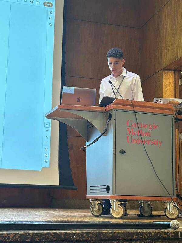 Alejandro Orcozo presenting a new member introduction at the 2025 C-CAS in person meeting