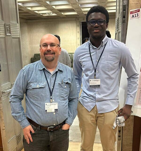 Osewuike Igue standing with his mentor, Dr. Isayev, at the C-CAS in person meeting at CMU